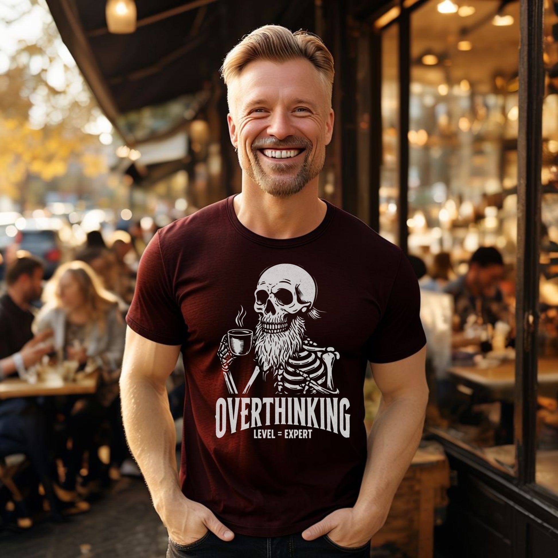 Man in oxblood black t-shirt, casual streetwear, men's graphic tee, smiling outdoors, urban cafe background, trendy unisex t-shirt, lifestyle fashion, overthinking expert shirt, skeleton graphic design, dark humor clothing, fall fashion, street style